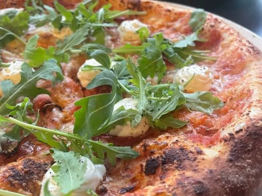 pizza med topping av ruccolablad