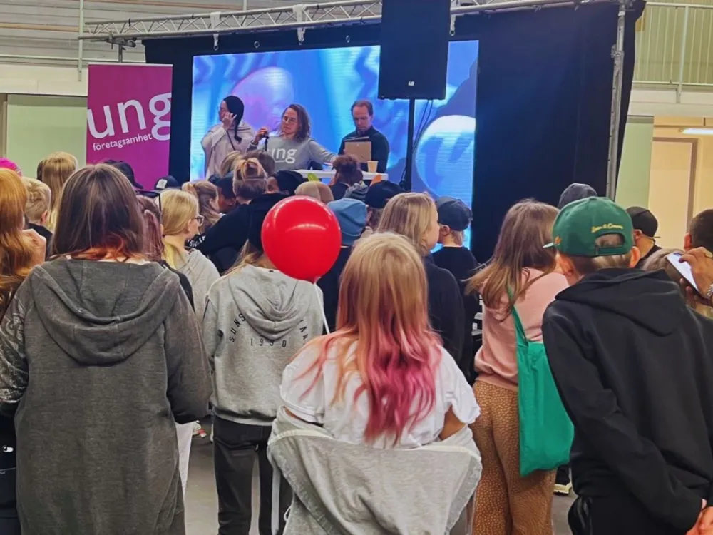 Barn och ungdomar framför en scen, sedda bakifrån
