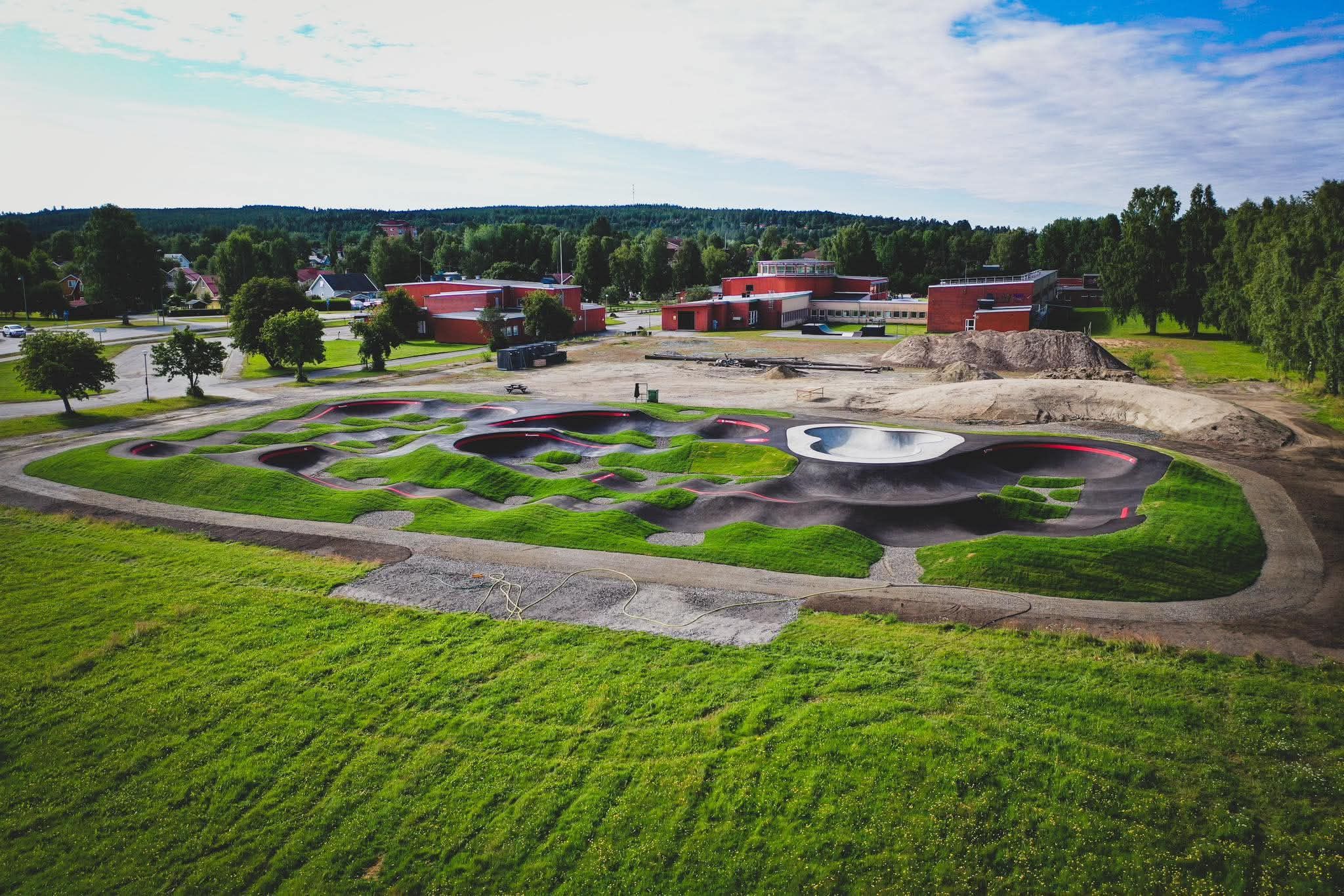 Översikt över pumptracken med Renforsskolan och omgivande bebyggelse i bakgrunden.